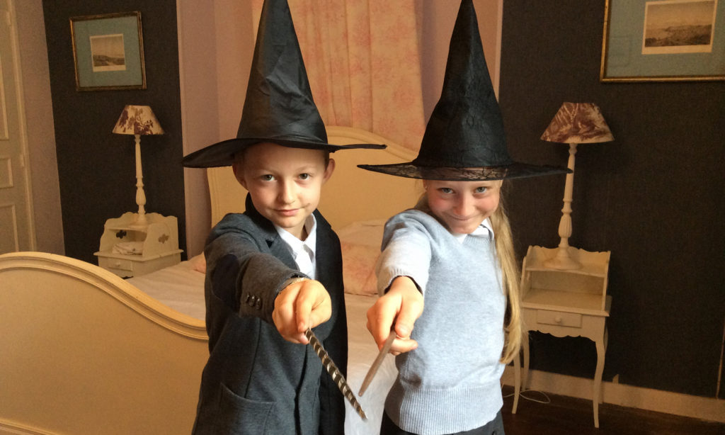 boy and girl wearing witch hats playing wizards